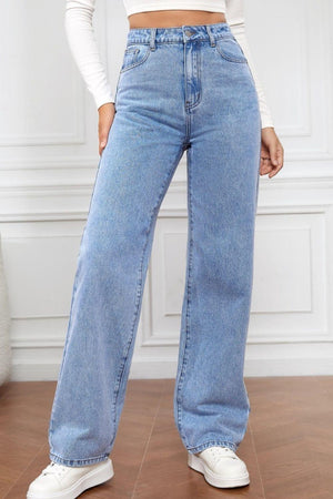 a woman standing on a wooden floor wearing a pair of jeans