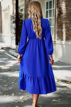 a woman in a blue dress walking down a street