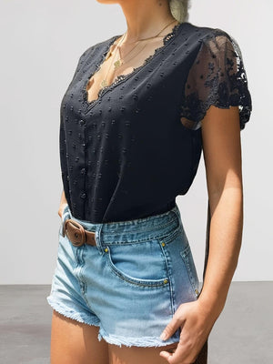 a woman wearing a black top and denim shorts