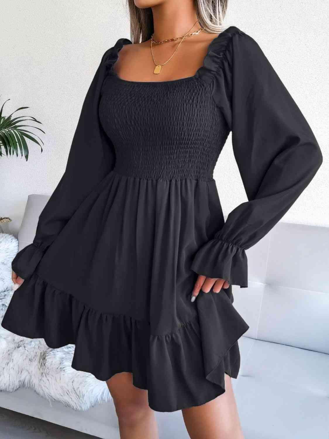 a woman wearing a black dress with long sleeves