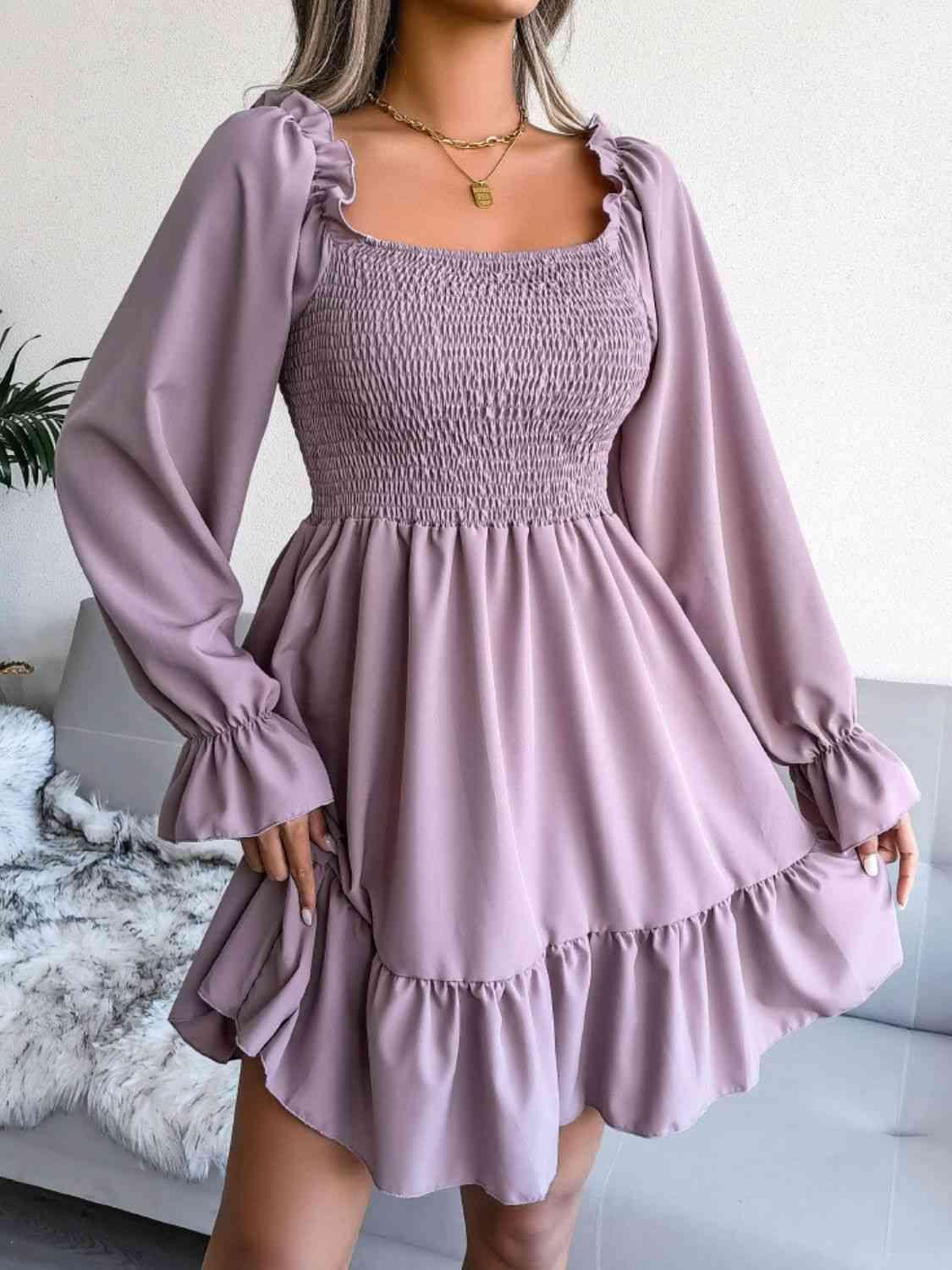 a woman wearing a purple dress with long sleeves