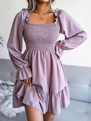 a woman wearing a purple dress with long sleeves