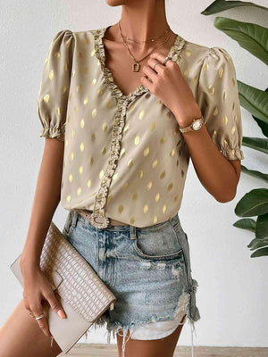 a woman wearing a polka dot blouse and denim skirt