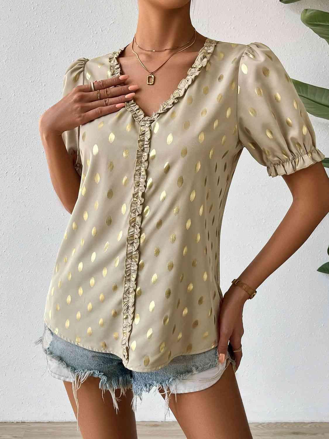 a woman wearing a blouse with gold polka dots