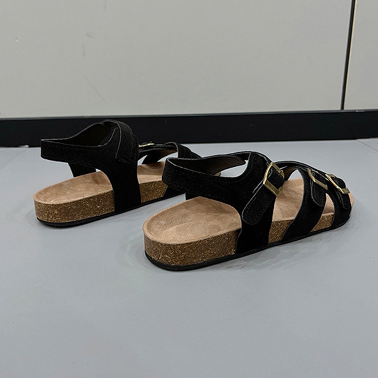 a pair of black sandals sitting on top of a counter