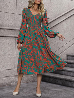 a woman wearing a green and red floral print dress