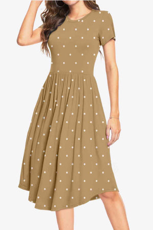 a woman wearing a brown dress with white polka dots