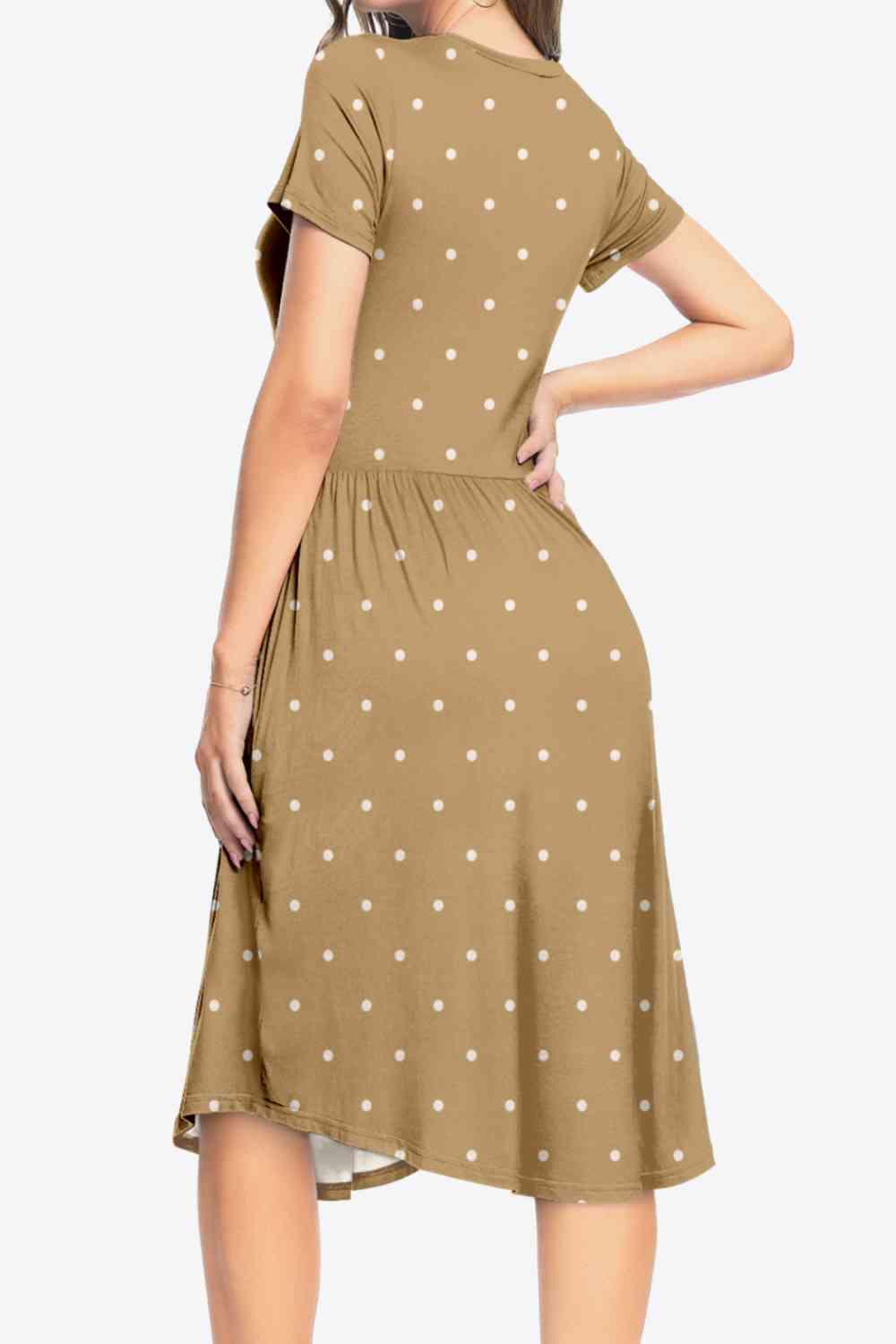 a woman wearing a brown dress with white polka dots