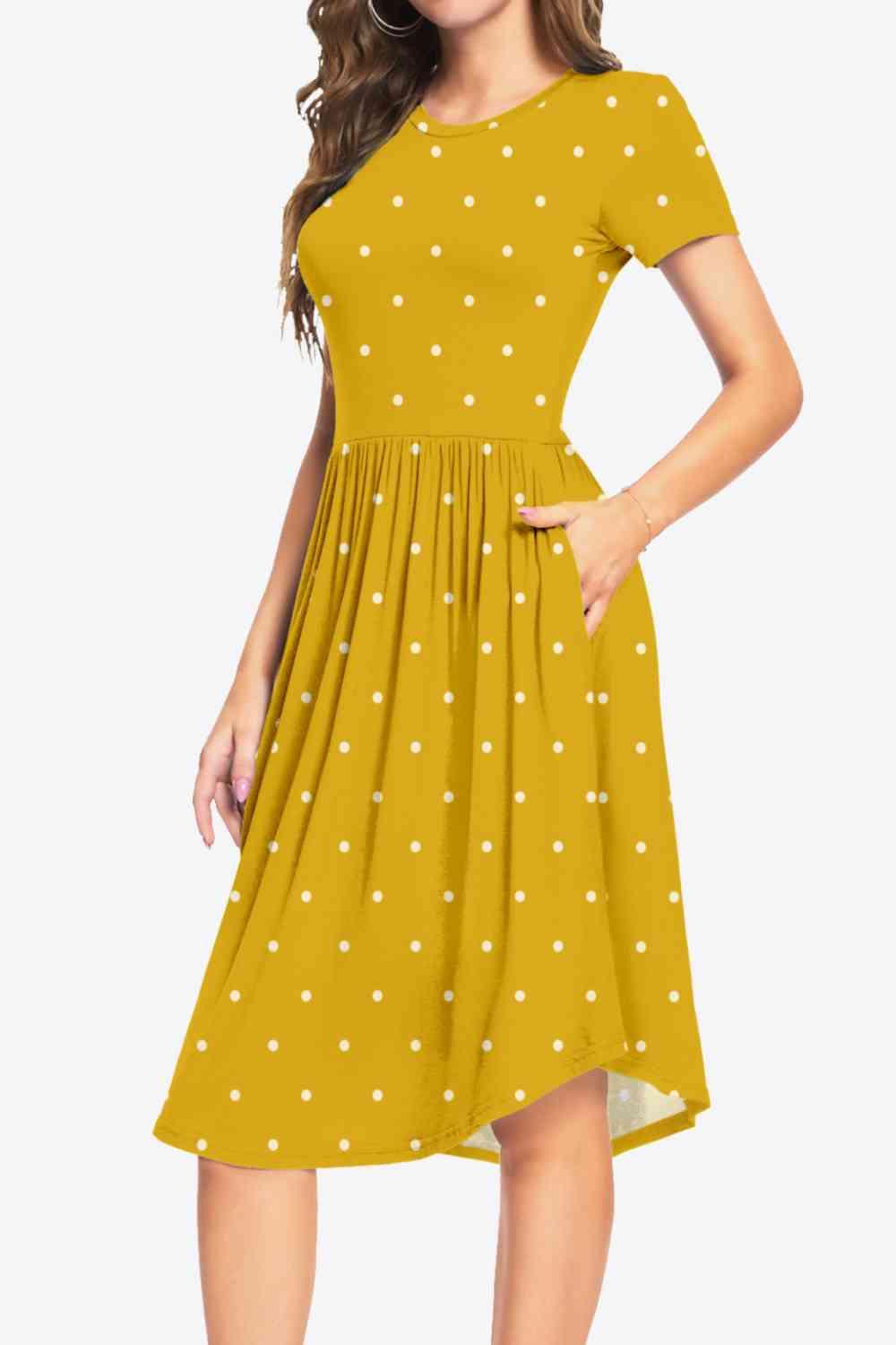 a woman wearing a yellow dress with white polka dots