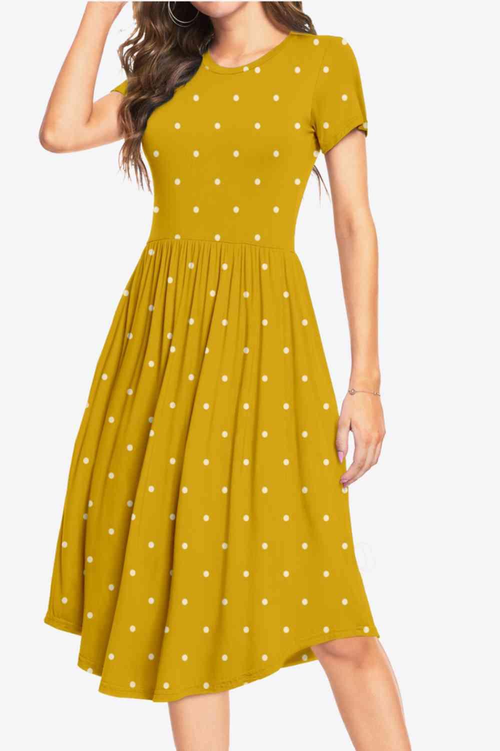 a woman wearing a yellow dress with white polka dots