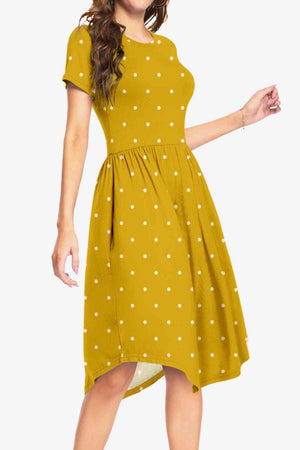 a woman wearing a yellow dress with white polka dots