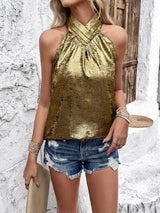 a woman wearing a gold top and denim shorts