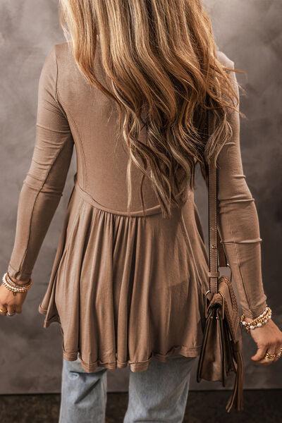 a woman with long hair standing in front of a wall