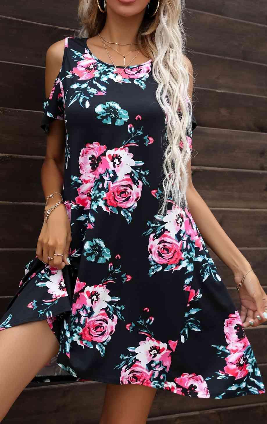 a woman wearing a black floral print dress