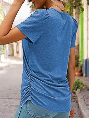 a woman in a blue shirt talking on a cell phone