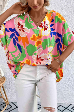 a woman wearing a colorful top and white jeans