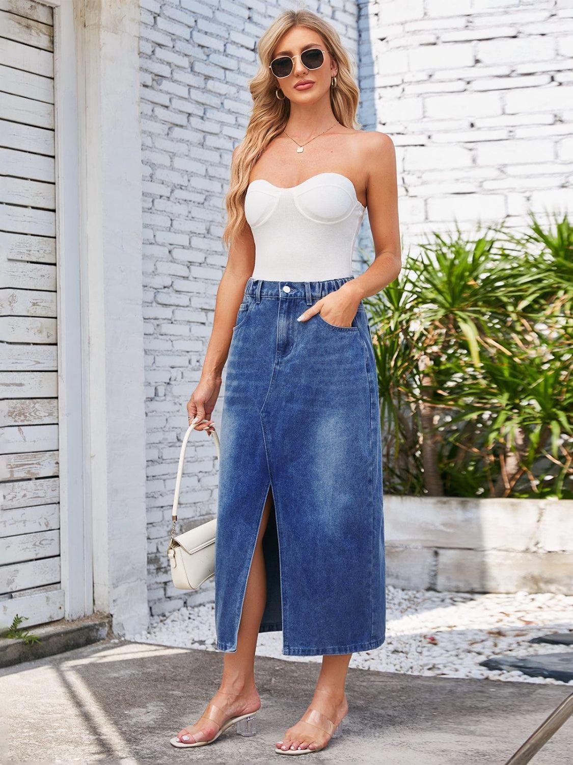 a woman wearing a white top and denim skirt