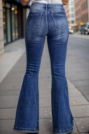 a woman is standing on the sidewalk with her back to the camera