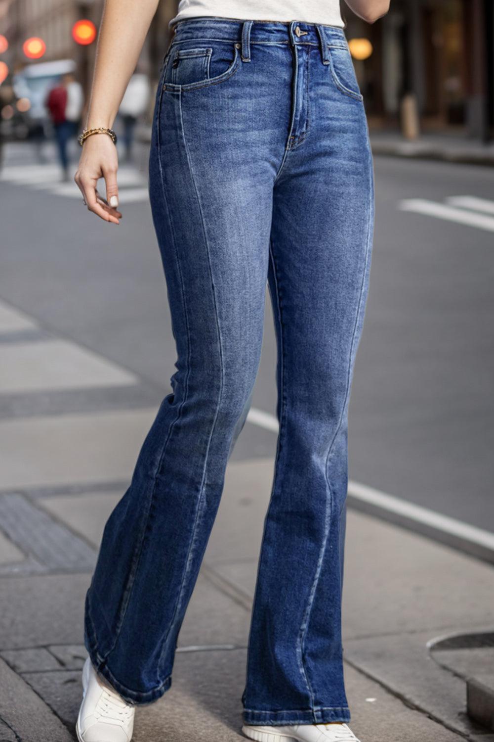 a woman is standing on the sidewalk talking on her cell phone