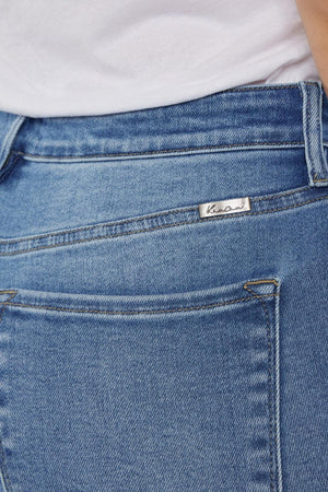 a close up of a person wearing a white shirt and blue jeans