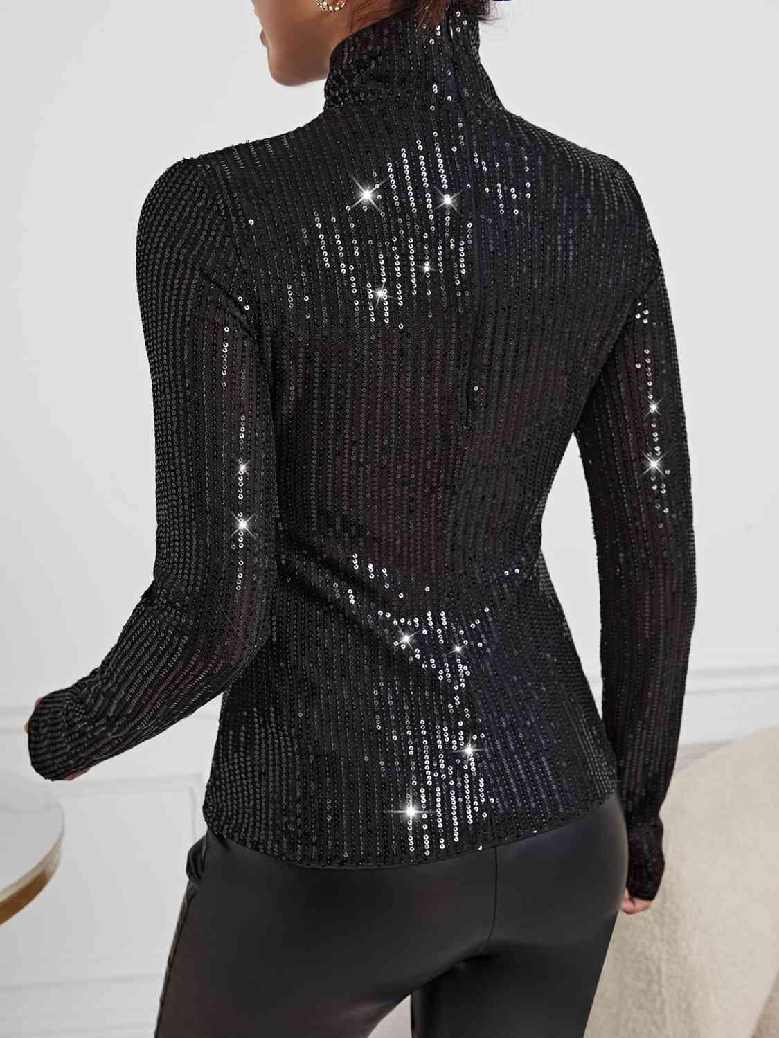 a woman wearing a black top with sequins on it