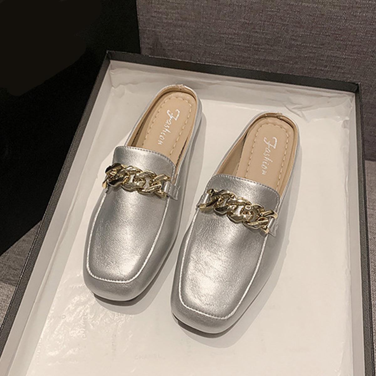 a pair of silver shoes sitting on top of a white box