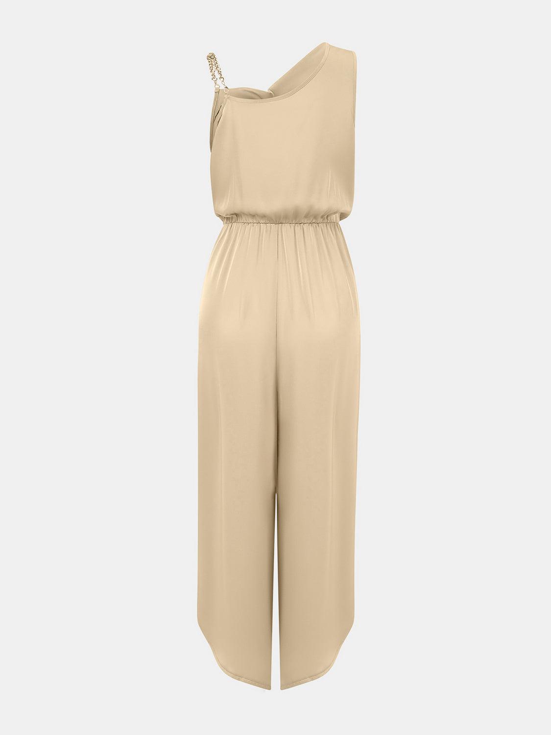 a woman wearing a beige jumpsuit with a halt neckline