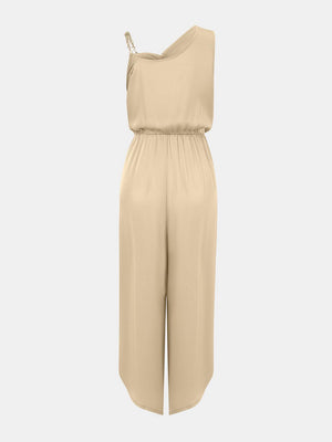 a woman wearing a beige jumpsuit with a halt neckline