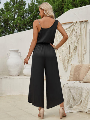 a woman wearing a black jumpsuit and heels