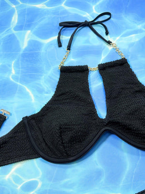 a black bikini top laying on top of a swimming pool