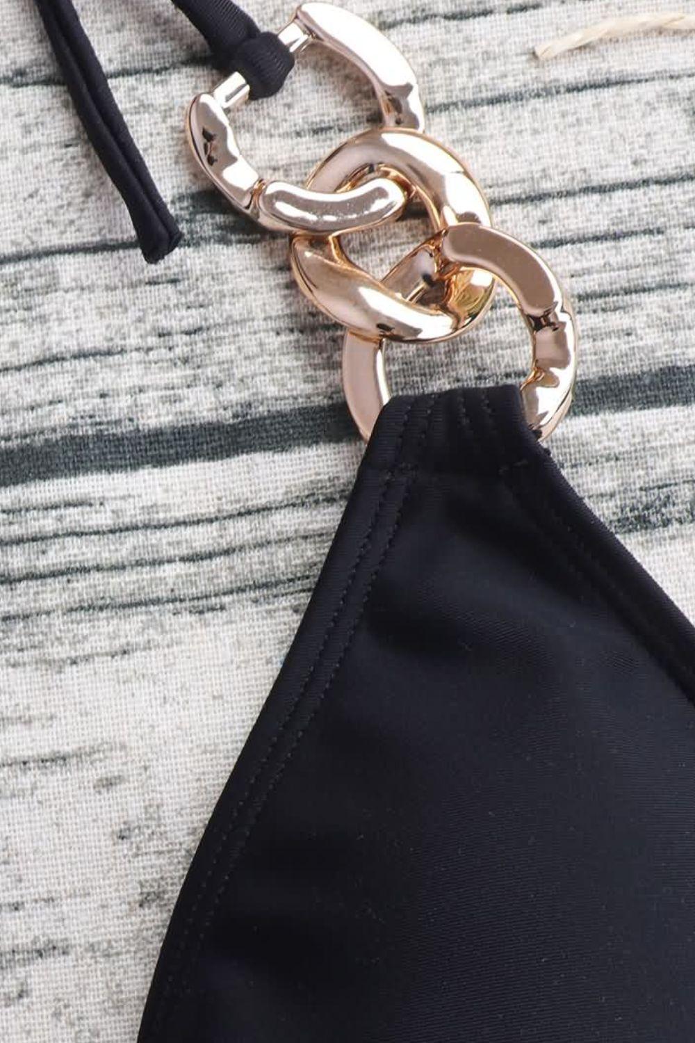 a black purse with a gold chain hanging from it