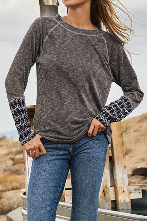 a woman standing on a beach next to a fence