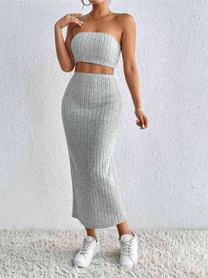 a woman wearing a grey two piece skirt and top