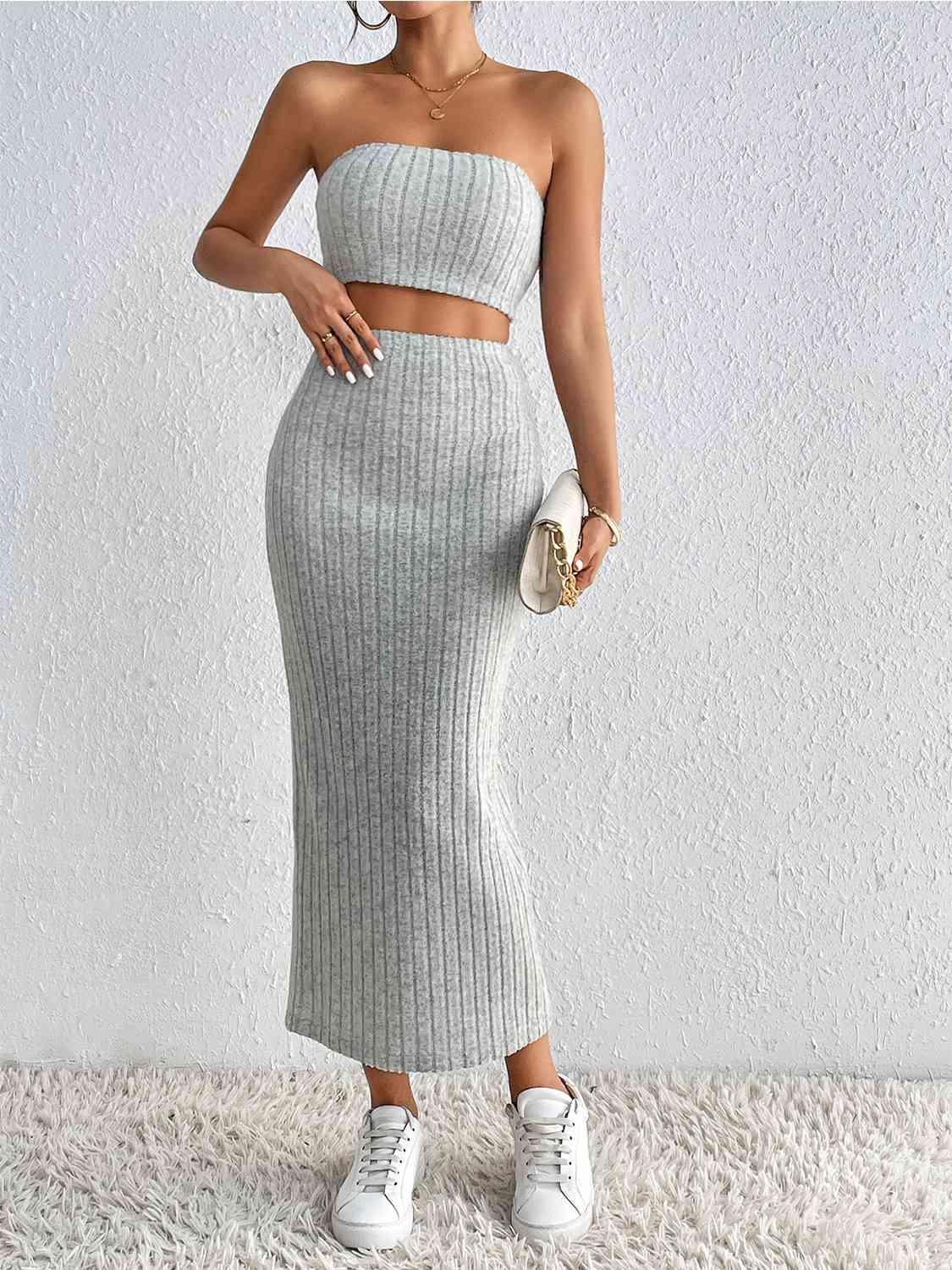 a woman wearing a grey two piece skirt and crop top