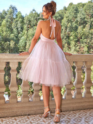 a woman in a pink dress standing on a balcony