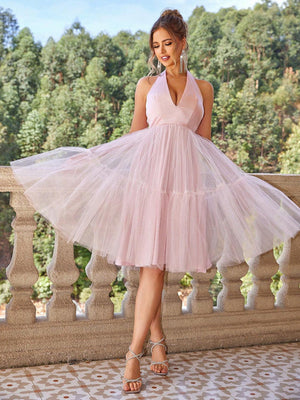 a woman in a pink dress standing on a balcony