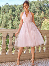 a woman in a pink dress standing on a balcony