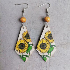 a pair of earrings with sunflowers painted on them