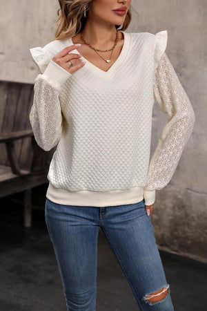 a woman wearing a white sweater and jeans