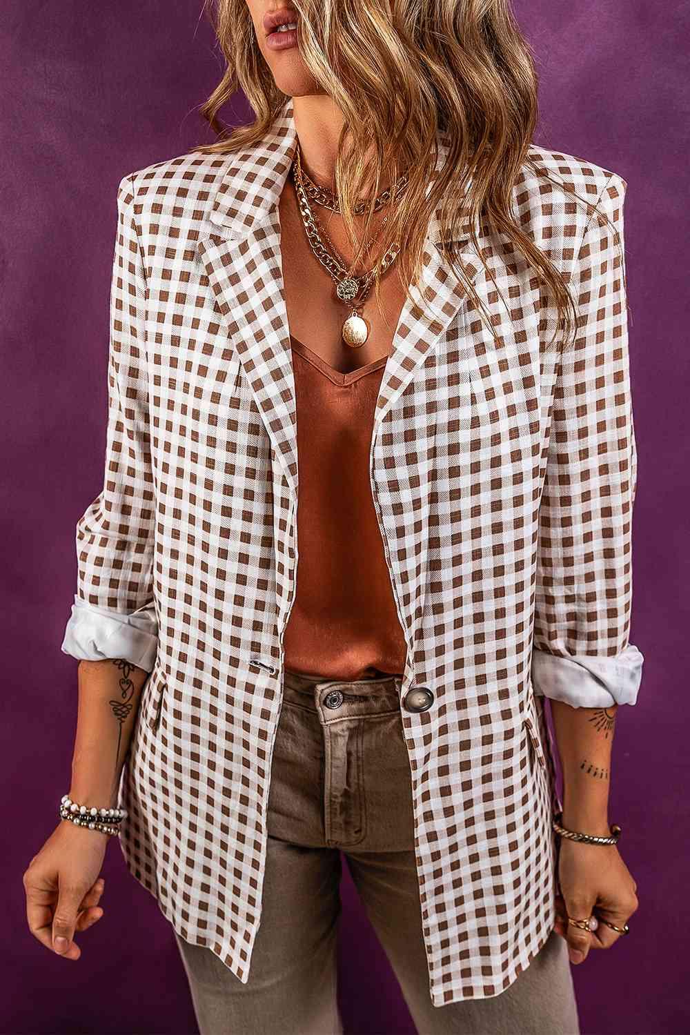 a woman wearing a white and brown checkered blazer