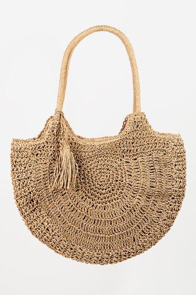 a straw bag with a tassel hanging from it