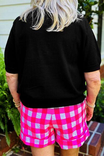 a woman wearing pink and white checkered shorts