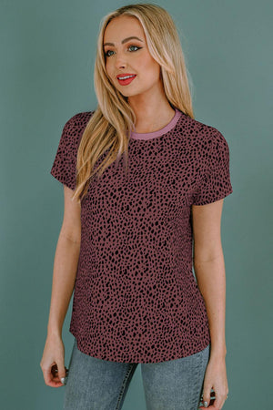 a woman wearing a red top with a leopard print on it