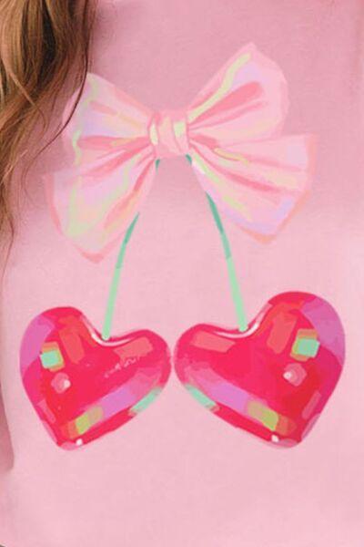 a woman wearing a pink shirt with two hearts on it