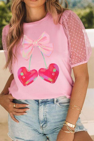 a woman wearing a pink shirt with two hearts on it