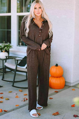 a woman standing on a porch wearing a brown jumpsuit