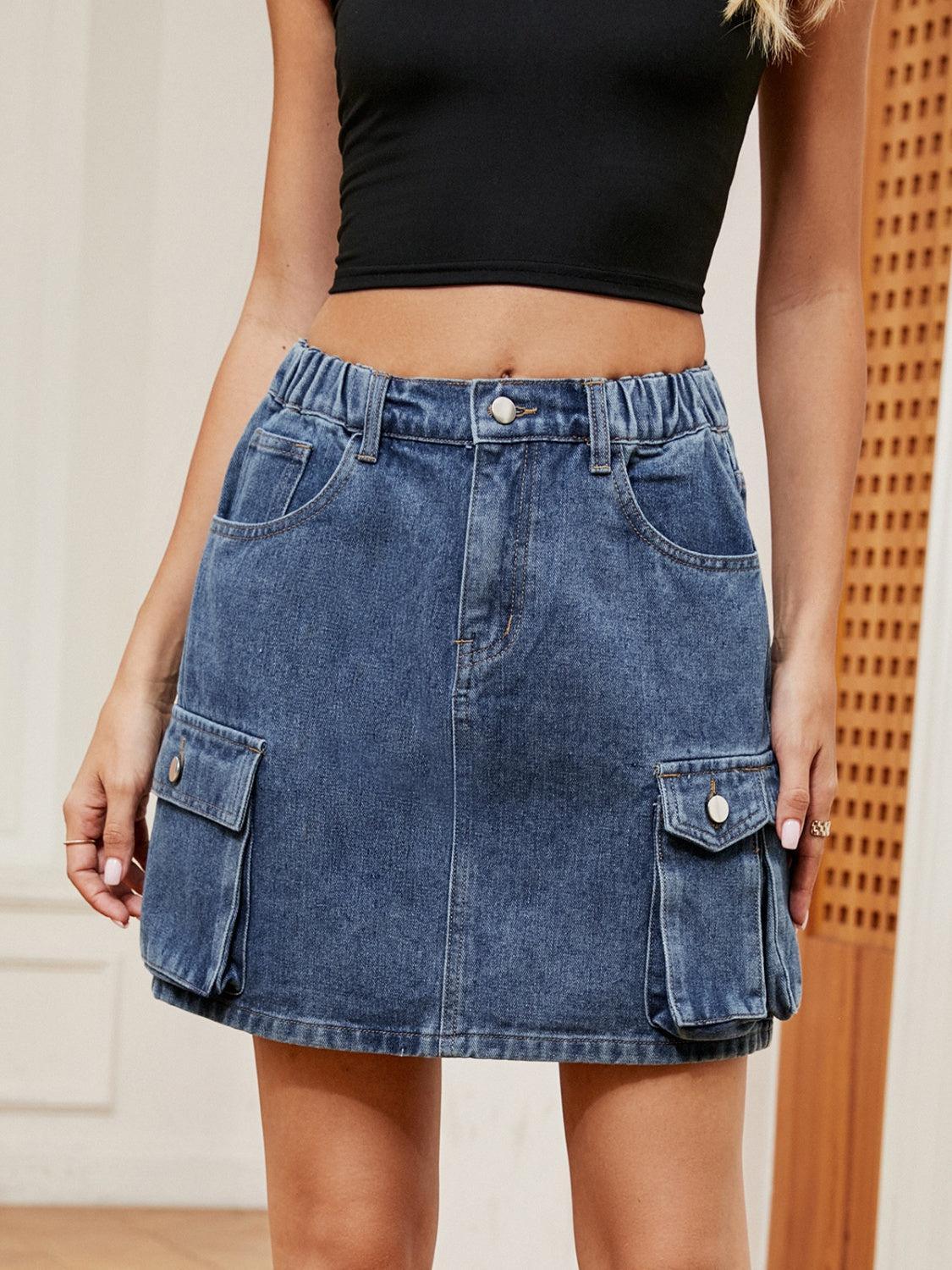 a woman in a black top and a denim skirt