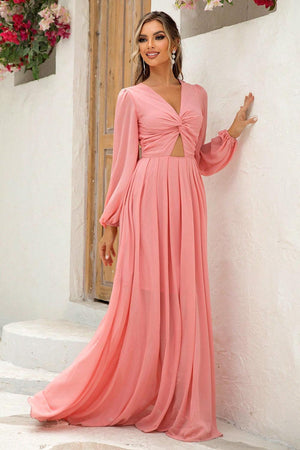 a woman in a pink dress leaning against a wall