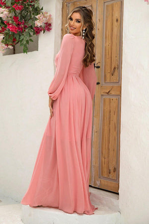 a woman in a long pink dress standing in front of a door