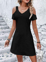 a woman wearing a black dress with cut outs